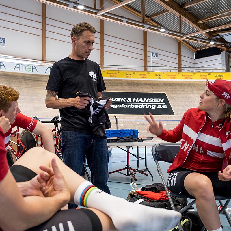 Cyclists sitting and wearing Apparel in support of their danish team. The graphical concept DENM