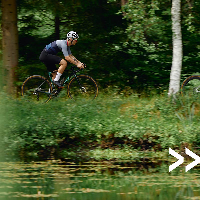 Cyclist riding through the forrest while wearing Willing Able Jersey from the new X.WA collection
