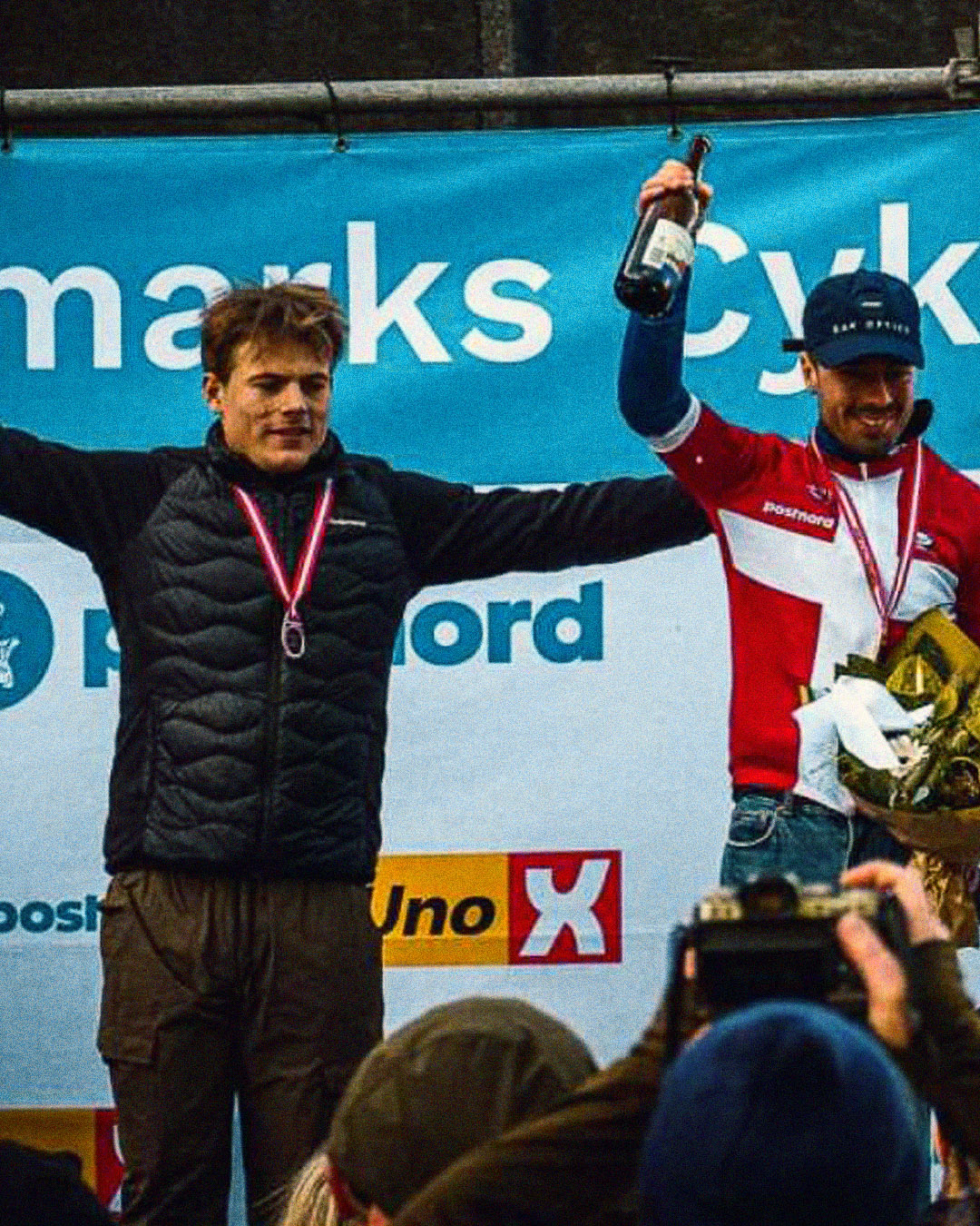 Winners of the gravel race with medals on and holding champagne.