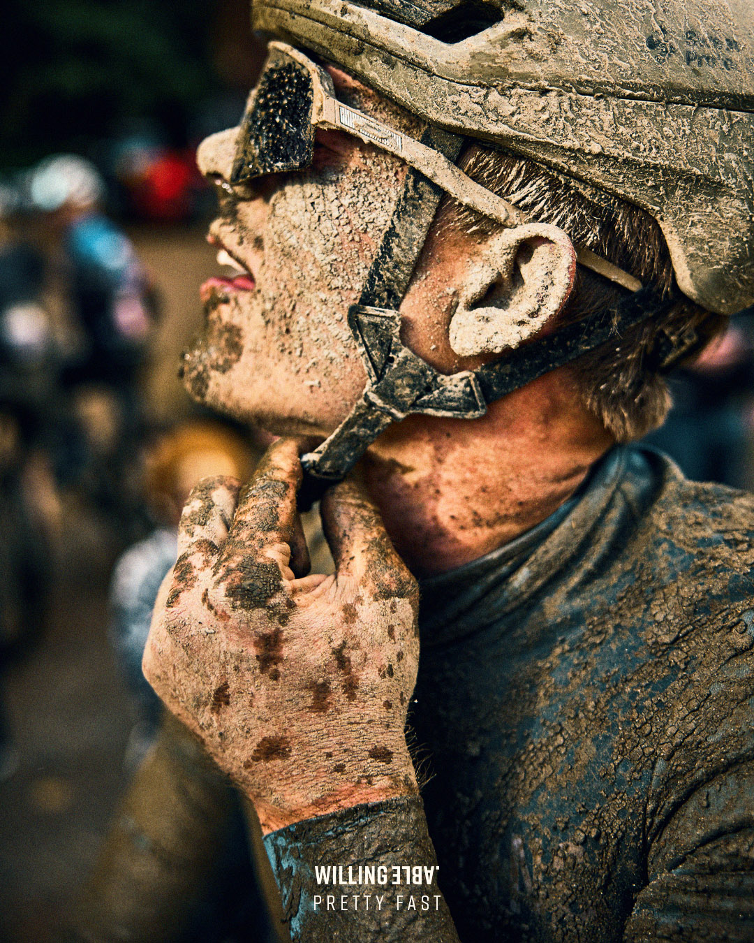 A Willing Able muddy rider at a gravel cycling race wearing Willing Able.