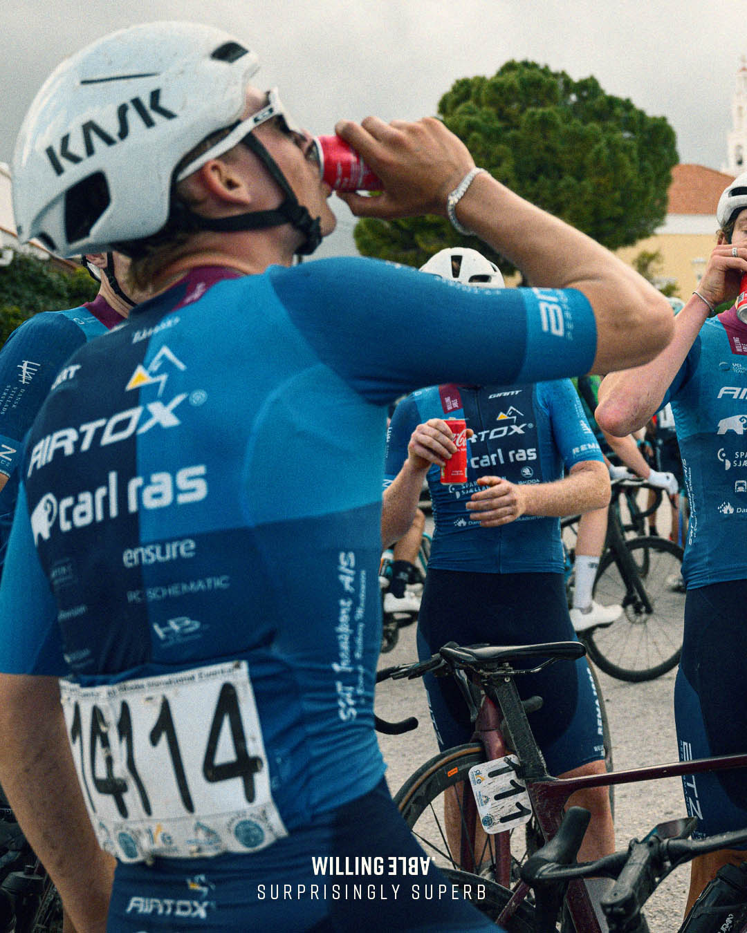 A performance cyclist in a race wearing a Willing Able blue shirt.