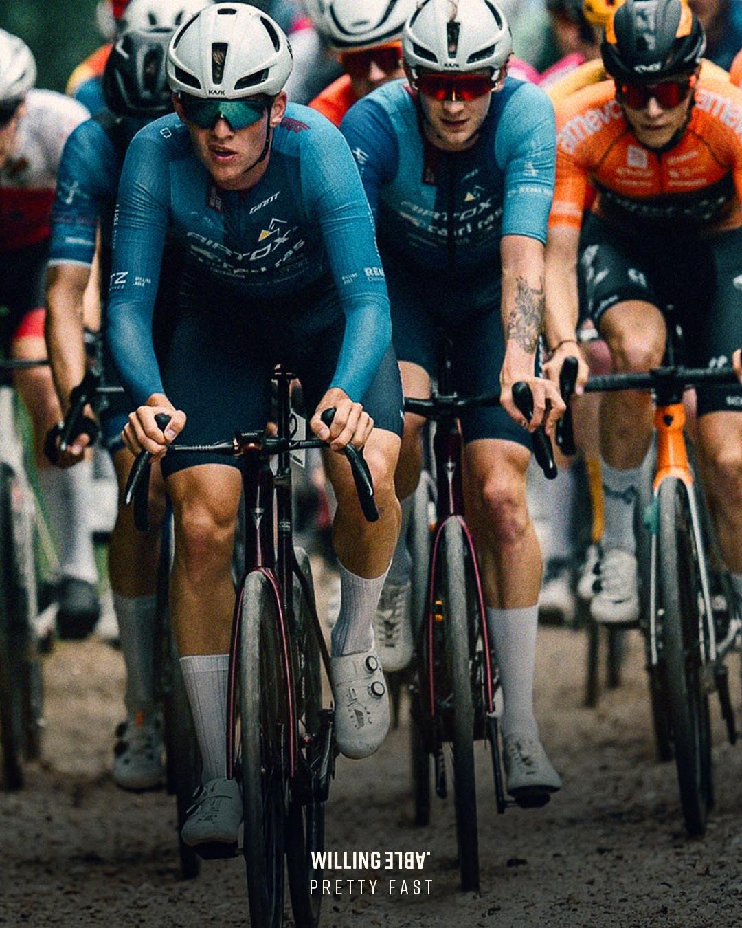 Severel cyclists in a race, wearing the brand Willing Able.